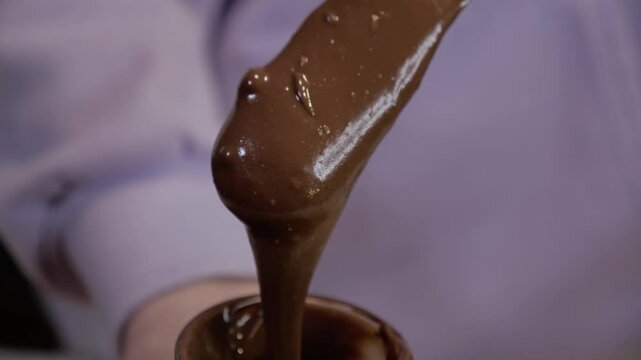 chocolate paste flows down the spatula. chocolate hazeltut spread. pastry chef. cooking dessert