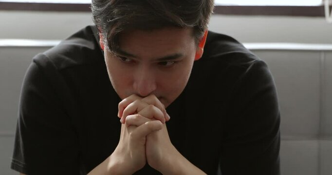 An Asian man in a moment of deep thought and reflection, expressing contemplation, depression, anxiety, and inner emotions