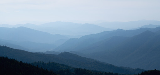 Obraz premium Rocky deep gorge with sharp sheer crags silhouettes against blue sky. Horizontal image.