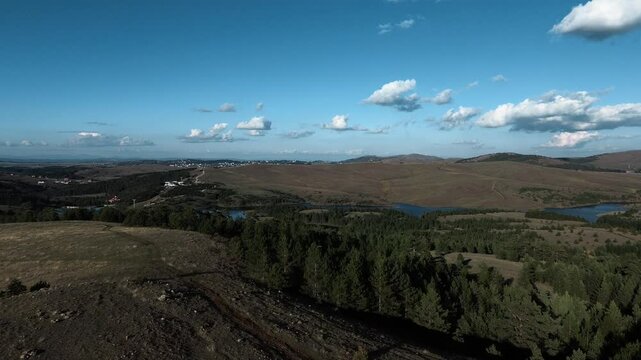 Nature of western Serbia in early autumn on a sunny warm day. Aerial sunset view from a drone of Lake Ribnichko in Zlatibor national park, next to the cable car leading to Mount Tornik