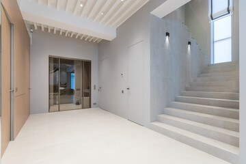 A bright hall with a glass door in a private house. Stairs to the second floor.