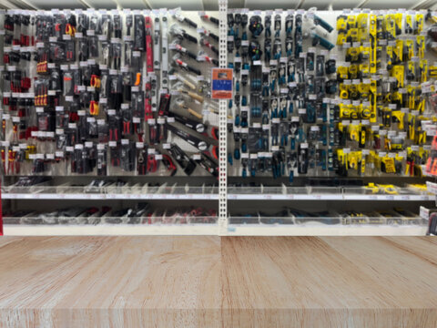 Wooden table top (counter bar) with blured Hand tools on shelf display at store for background. Banner for advertise on online media. For montage product display visual layout. Shopping concepts.
