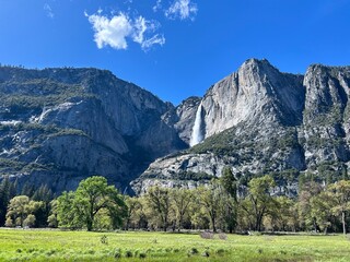 autumn in the mountains with waterfall and green meadow 