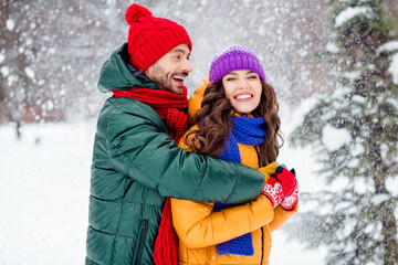 Fototapeta premium Photo of charming funny marriage couple wear windbreakers walking snowy weather cuddling smiling outside park