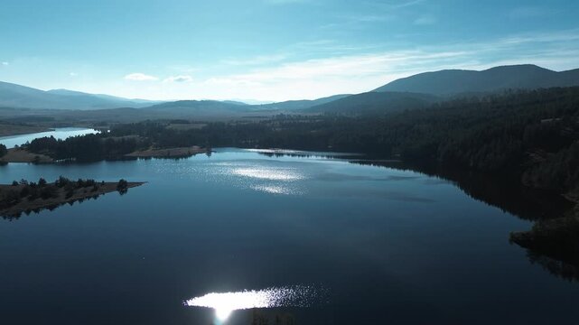 Nature of western Serbia in early autumn on a sunny warm day, Zlatibor town popular among tourists. Aerial view from a drone of Lake Ribnichko, next to the cable car leading to Mount Tornik
