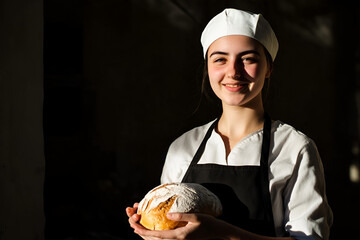 Young baker proudly showcasing freshly baked bread in a warm kitchen setting during golden hour