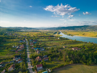 Rural landscape viewed from the drone. A village in Romania located on the edge of a lake near the...