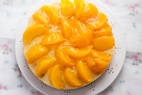 Cake with vanilla cream, peaches and white glaze 