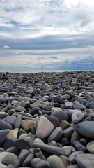 Sea, beach and pebbles, clouds in the sea.
