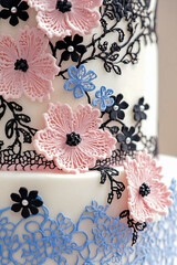 Pastel gothic cake decorated with pink, blue, white and black elements.