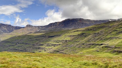 Fototapeta premium paysage du Fjord de Seydisfordjur en Islande en été entre montagne verte et cascade et chute d'eau
