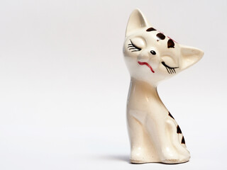 In tis photoillustration Vintage porcelain figurine of cat on white background