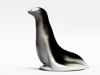 In tis photoillustration Vintage porcelain figurine of fur seal on white background