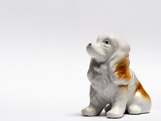 In tis photoillustration Vintage porcelain figurine of dog on white background