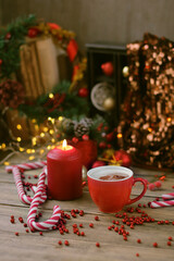 Christmas and new year holiday background. Christmas decorations, candle, candy canes and cocoa cup on wooden table. symbol of festive winter season. magic fairy tale atmosphere. soft focus
