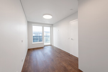 Empty white walls room corner and window. Interior with empty room with white walls and wooden floor.