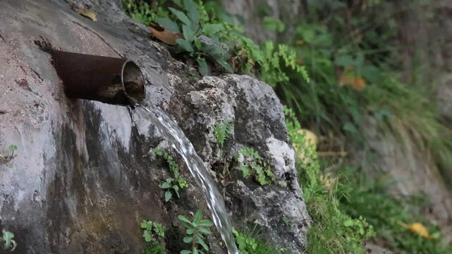 Agua fluye desde tubo de hierro oxidado en el chorrador de Alcoy, Espa&ntilde;a