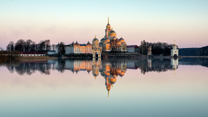 Obraz premium a soft pink dawn and a view of the Nilo-Stolobensky monastery