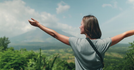 Young tourist is embracing the breathtaking view of mayon volcano in the philippines, feeling a sense of freedom and awe