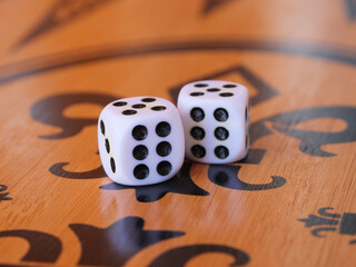 Two white dice sit on an ornate wooden board, showing double six combination with black dots.
