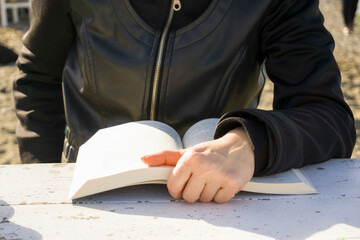Person reading a book outdoors, capturing a moment of quiet and focus.