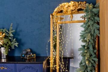 Vintage golden mirror near blue wall