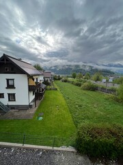Fototapeta premium Scenic mountain view with cloudy sky over suburban houses in Austria