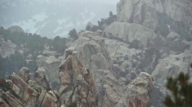 Telephoto pan up on rock formations in a snowstorm in Castle Rocks State Park, Idaho