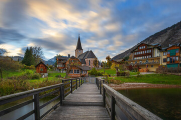 A small church by Lake Altaussee, surrounded by small wooden houses and a hotel.