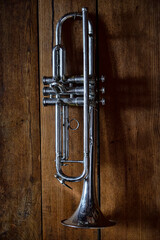Fototapeta premium A vintage silver trumpet displayed against a rustic wooden background