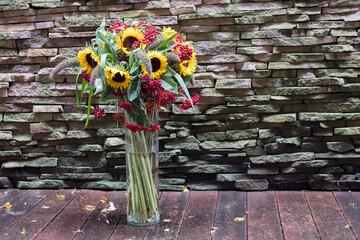 A bouquet of sunflowers and red viburnum on the porch of a house for decoration...