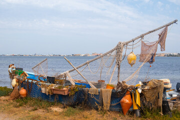 Obraz premium Rustic Fishing Boat with Nets and Buoys by the Water in Sète, France