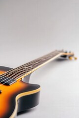 Close-up of a sunburst electric guitar against a plain background