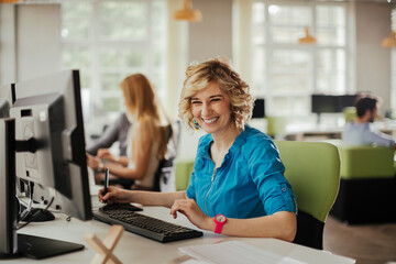Obraz premium Young women using a computer while working in a startup company office