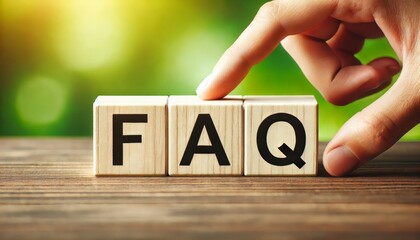 FAQ wooden blocks with hand on green background