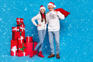 Portrait of beautiful handsome trendy friends friendship carrying gifts eve time isolated over bright blue color background