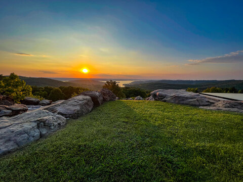 Mountain top view in sunset with rocks and grass field