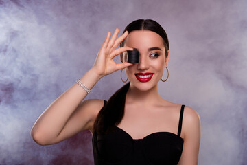 Photo of pretty model girl poker tokens cover eye look empty space isolated on maroon smoke background