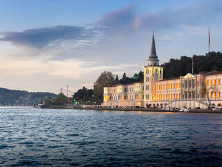 Obraz premium A large building with a tall spire sits on the shore of the Bosphorus in Istanbul, Turkey