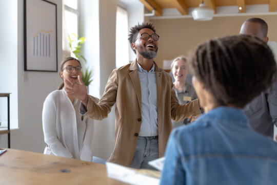 A dynamic leader energizes team members in an open office, fostering a collaborative, motivational atmosphere centered on teamwork and shared success. Concept: inclusive leadership