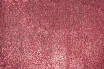 Fragment of a rusty grunge surface. Dark red background color. Scuffs and peeling of old paint....