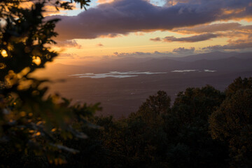 Fototapeta premium Sunset in a mountain area with water in the background with autumn light