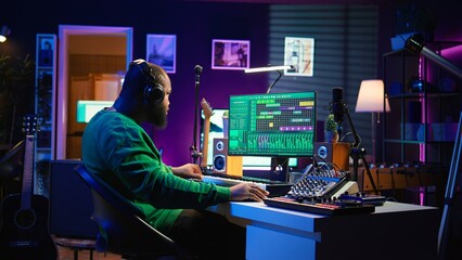 Music composer adding tracks as sound effects for a new song, recording sounds on electronic piano...