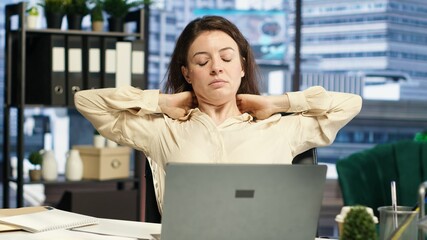 Woman CEO dealing with muscle cramps due to incorrect posture at the desk, having neck and back...