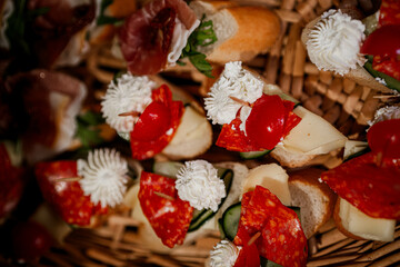 A variety of mini sandwiches are arranged in a rustic basket, ideal for cocktail events, family gatherings, or picnics. 