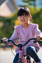 Obraz premium 自転車の練習に挑戦する小学生の女の子