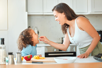 Woman, child and feeding with smile, help and guidance for cooking and support in kitchen. Mother,...