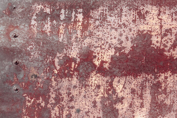 Fragment of a rusty grunge surface. Orange-brown background color. Scuffs and peeling of old paint. Scratches and traces of a welding seam.