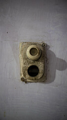 Close-up of an old, dusty vintage light switch on a textured wall, showing age and wear. Ideal for concepts related to history, vintage decor, or retro technology.