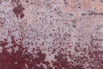 Fragment of a rusty grunge surface. Orange-brown background color. Scuffs and peeling of old paint. Scratches and traces of a welding seam.